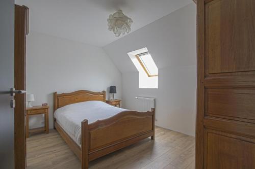 Un dormitorio con una cama de madera y una puerta de madera. en La maison des marronniers, en Bayeux