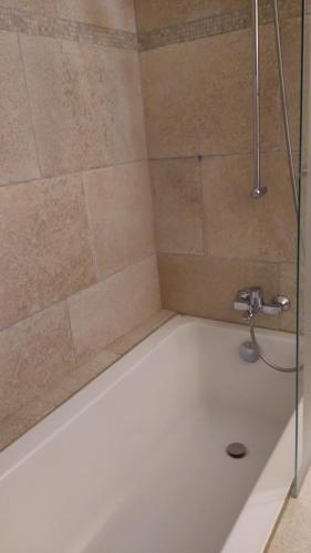 d'une douche avec une baignoire blanche avec un pommeau de douche. dans l'établissement La Baraka, à Pianottoli-Caldarello