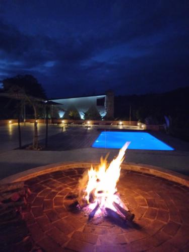 a fire pit in front of a pool at night at Fijnbosch Game Lodge Jeffreys Bay in Jeffreys Bay