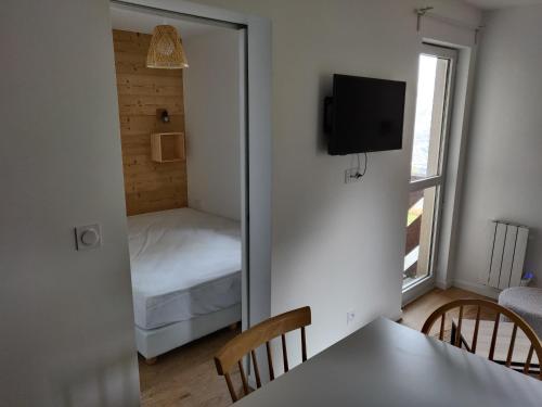 a room with a mirror and a bedroom with a bed at Appartement neuf 4-6 pers. aux pieds des pistes in Génos