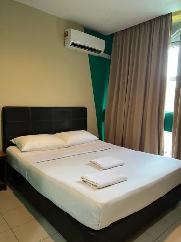 1 dormitorio con 1 cama con 2 toallas en Venice Inn en Miri