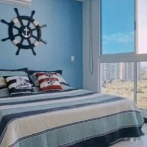 1 dormitorio con 1 cama y una ventana con un barco en la pared en Apartamento Vacacional para Familias en Pozos Colorados Santa Marta, en Santa Marta