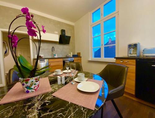 une table de salle à manger avec un vase de fleurs dessus dans l'établissement Ferienwohnung Beletage, à Varel