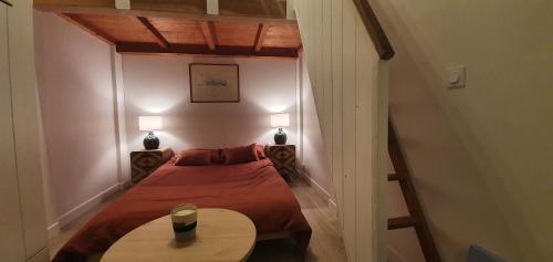 a small bedroom with a bed and a table at Villa Babeth by Nuits au Port in La Rochelle