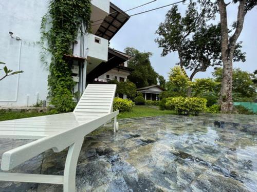 a white bench sitting outside of a house at ilamparuma Hotel in Weligama