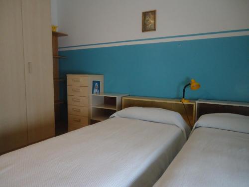 ein Schlafzimmer mit 2 Betten und einer blauen Wand in der Unterkunft Protezione della Giovane - female hostel in Verona