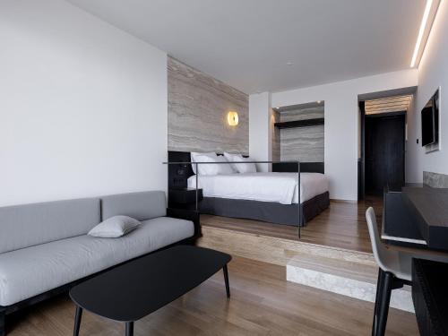 a living room with a bed and a couch at The Tanneries Hotel & Spa - a Member of Design Hotels in Chania Town