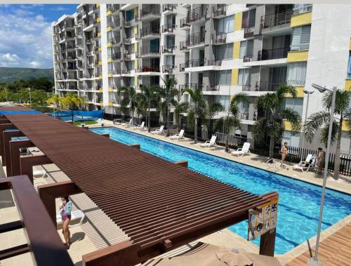 una grande piscina con un grande edificio di Acogedor Apart piscina, descanso y teletrabajo a Ricaurte