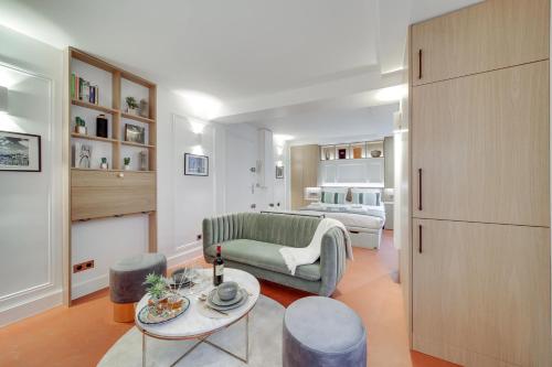 un salon avec un canapé et une table dans l'établissement Amazing Historical Parisien Flat Next To Louvre Area - 3, à Paris