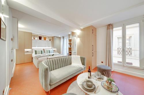 un salon avec un canapé et un lit dans l'établissement Amazing Historical Parisien Flat Next To Louvre Area - 3, à Paris