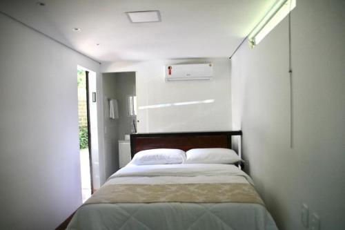 een slaapkamer met een bed in een witte kamer bij Econtainer Suítes Macacos in Macacos