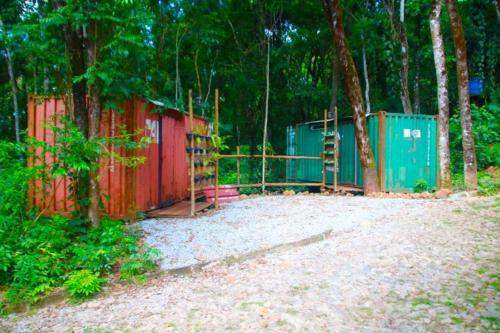 a playground with a fence and some trees at Econtainer Suítes Macacos in Macacos