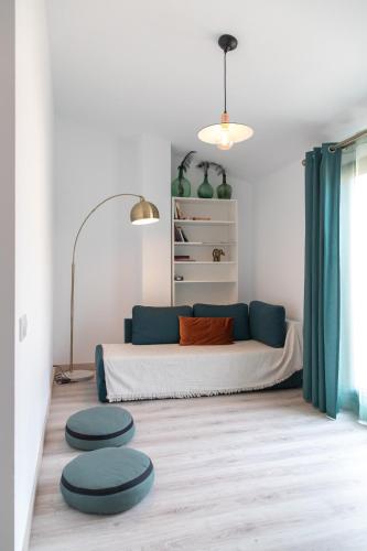 a living room with a bed and two stools at Spiral Stairs Duplex in Figueres