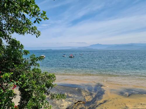 a view of a beach with people in the water at Paraíso Azul Retiro in Abraão