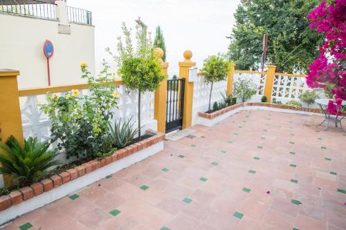 a patio with a fence and flowers in a yard at Elmiradordelasmurallas in Baeza