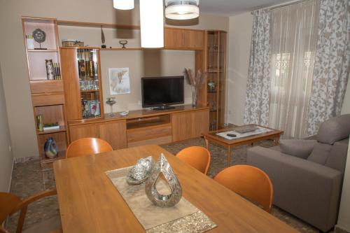 a living room with a dining table and a television at Elmiradordelasmurallas in Baeza