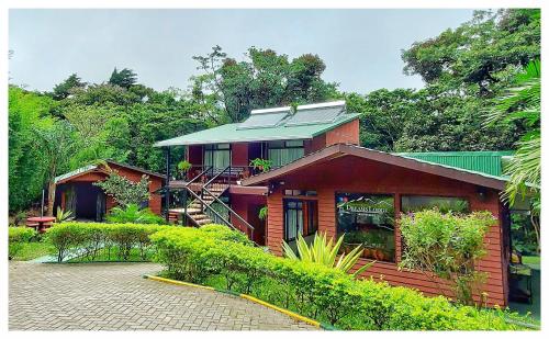 Casa de madera con techo verde en Dreams Lodge, en Monteverde