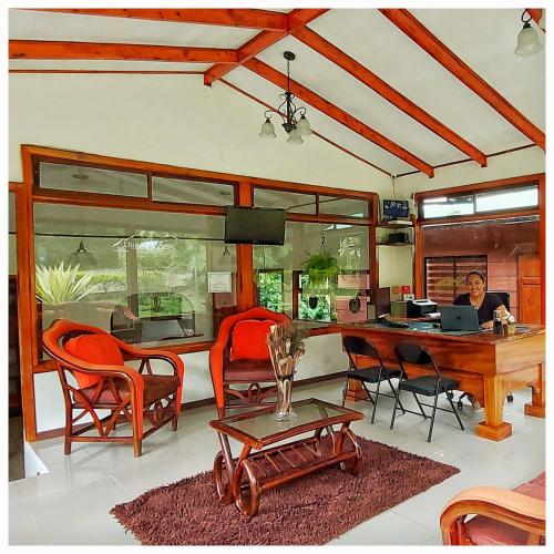 a person sitting at a table with a laptop in a room at Dreams Lodge in Monteverde Costa Rica