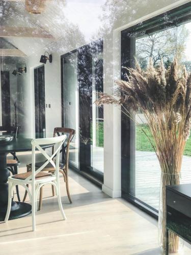a dining room with glass doors and a white chair at Pärli puhkemaja / Pearl riverside house in Pudisoo