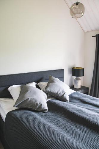 a bed with pillows on it in a bedroom at Pärli puhkemaja / Pearl riverside house in Pudisoo