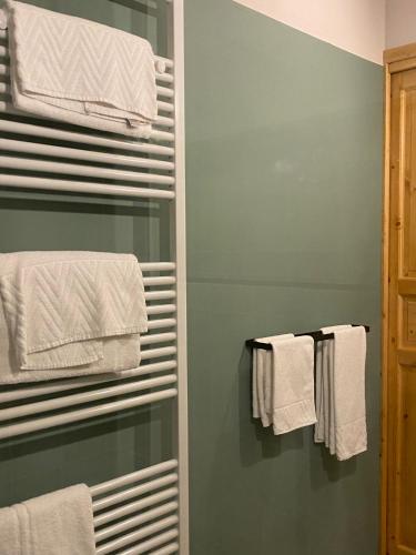 a bathroom with green walls and white towels at Casimiro Rooms in Cesena