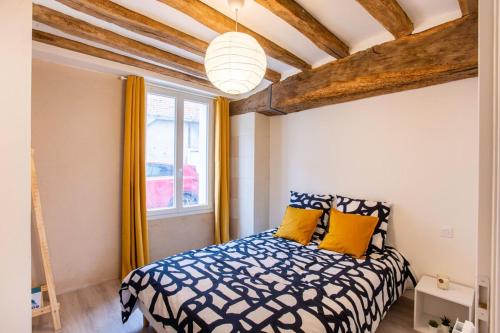 a bedroom with a bed with yellow pillows at LE VINCI Échappée Amboisienne avec sauna partagé in Amboise