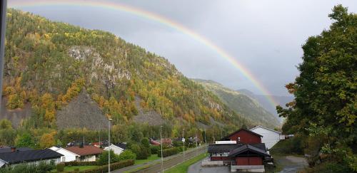 a rainbow in the sky over a town with a mountain at Studio 5 in Dalen