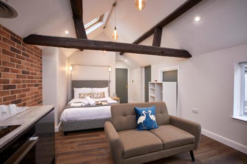 um quarto com uma cama, um sofá e uma cadeira em Three Cranes Serviced Apartments em Sheffield