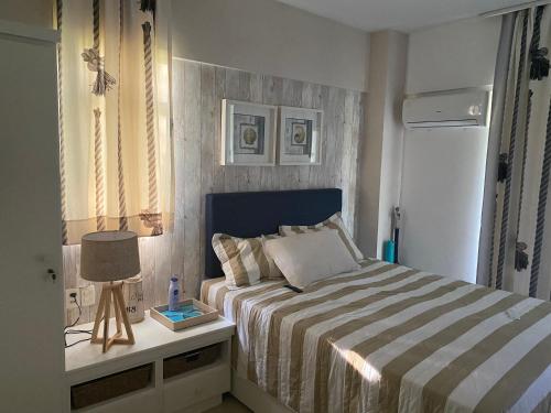 Resort Beach Place في أكويراز: غرفة نوم بسرير وطاولة مع مصباح
