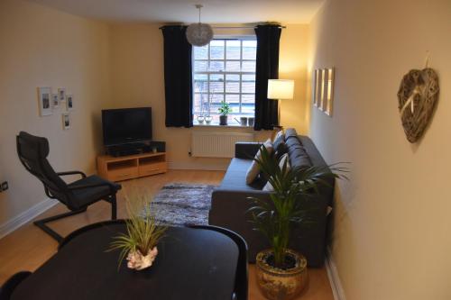 a living room with a couch and chairs and a tv at Scandinavian City Centre Apartment in Worcester