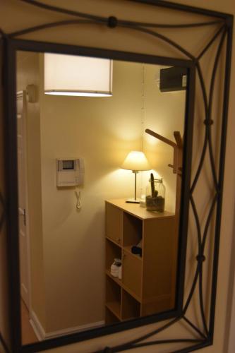 a mirror reflecting a room with a lamp on a table at Scandinavian City Centre Apartment in Worcester