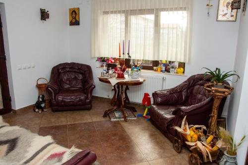 sala de estar con 2 sillas de cuero y mesa en Casa Albert Sinaia en Sinaia