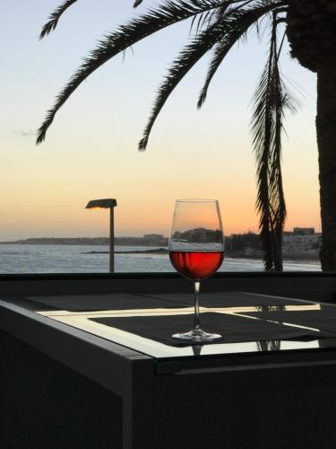 - un verre de vin assis sur une table près de l'océan dans l'établissement Exclusives Apartment 10 meters to Ocean, à Maspalomas