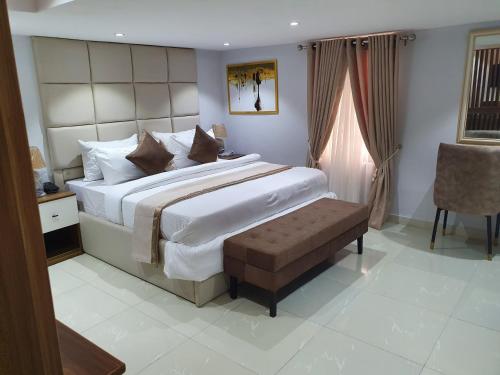 a bedroom with a large bed and a chair at Choice Luxe Lagos in Ikeja