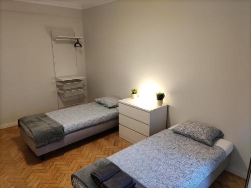 1 dormitorio con 2 camas y vestidor con espejo en Memoria 49 - 21 en Lisboa