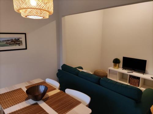ein Wohnzimmer mit einem blauen Sofa und einem Tisch in der Unterkunft Memoria 49 - 21 in Lissabon