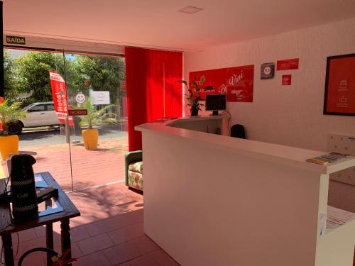 a shop with a counter and a red curtain at Hotel Praia Bonita in Capão da Canoa