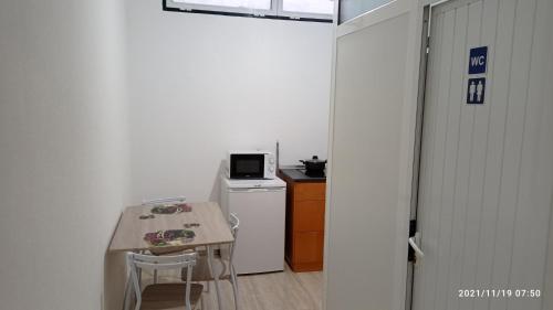 une petite cuisine avec une table et un réfrigérateur dans l'établissement Cantinho dos Remédios, à Lajes
