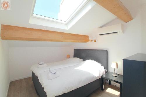une chambre avec un lit et une lucarne dans l'établissement ALC - MONT8 - 8 min Palais and Beaches, à Cannes