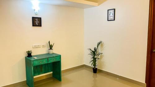 a room with a green table and a plant at Calvin's Retreat in Varca