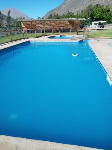 a large swimming pool with blue water at Cabañas Rivadavia Spa in Vicuña