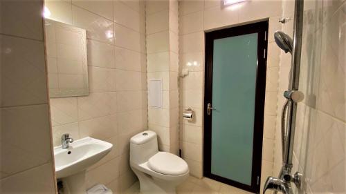a white bathroom with a toilet and a sink at Prime Apartments in Bansko