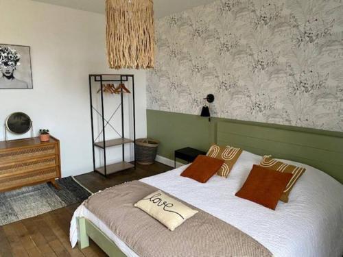 une chambre avec un grand lit avec deux oreillers dessus dans l'établissement Au Petit Bragard- triplex proche centre ville, à Saint-Dizier