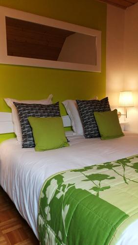 a green bedroom with a large bed with green pillows at A l'Arbre Vert in Wintzfelden