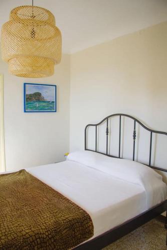 ein Schlafzimmer mit einem Bett und einer hängenden Lampe in der Unterkunft Casa Paz, centro storico vista mare in Bordighera