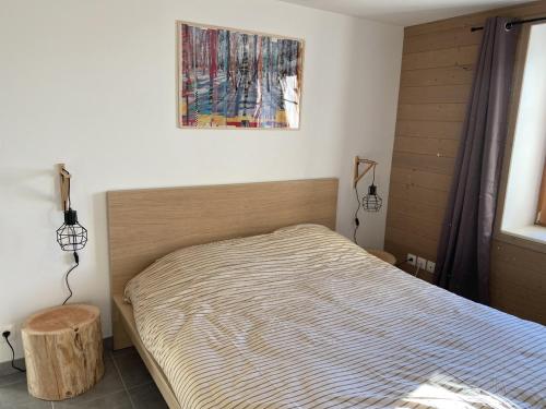una camera con un letto e una foto appesa al muro di L'apparté, 83m² pour s'évader en famille ou à deux a Gérardmer
