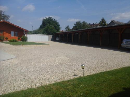 a gravel driveway with a parking meter in the grass at Petrovics Apartmanház 1 in Bük