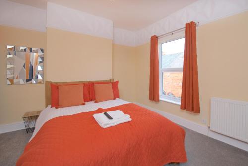 ein Schlafzimmer mit einem roten Bett und einem Fenster in der Unterkunft Ideal Abode Leonard chester in Chester