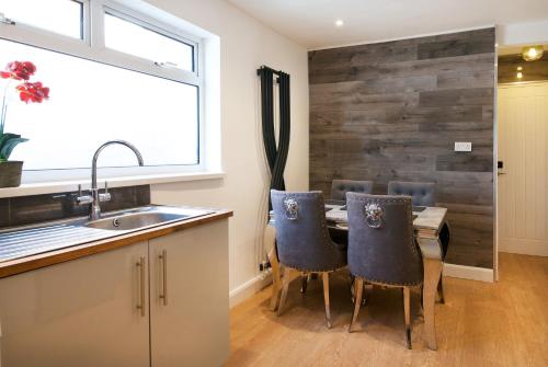een keuken met een tafel met stoelen en een wastafel bij Ideal Abode Leonard chester in Chester