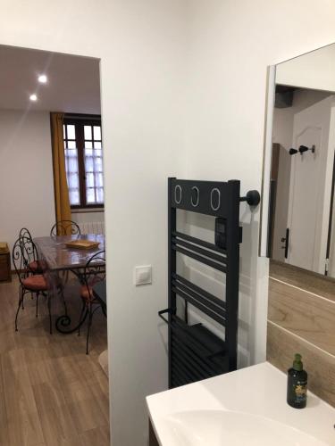 a kitchen and dining room with a table and a mirror at En toute simplicité in Bielle
